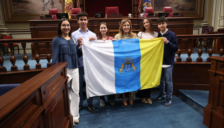 La presidenta del Parlamento entrega la bandera canaria que acompañará a los estudiantes seleccionados para la Ruta Quetzal 2026